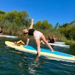 girl on paddleboard doing yoga